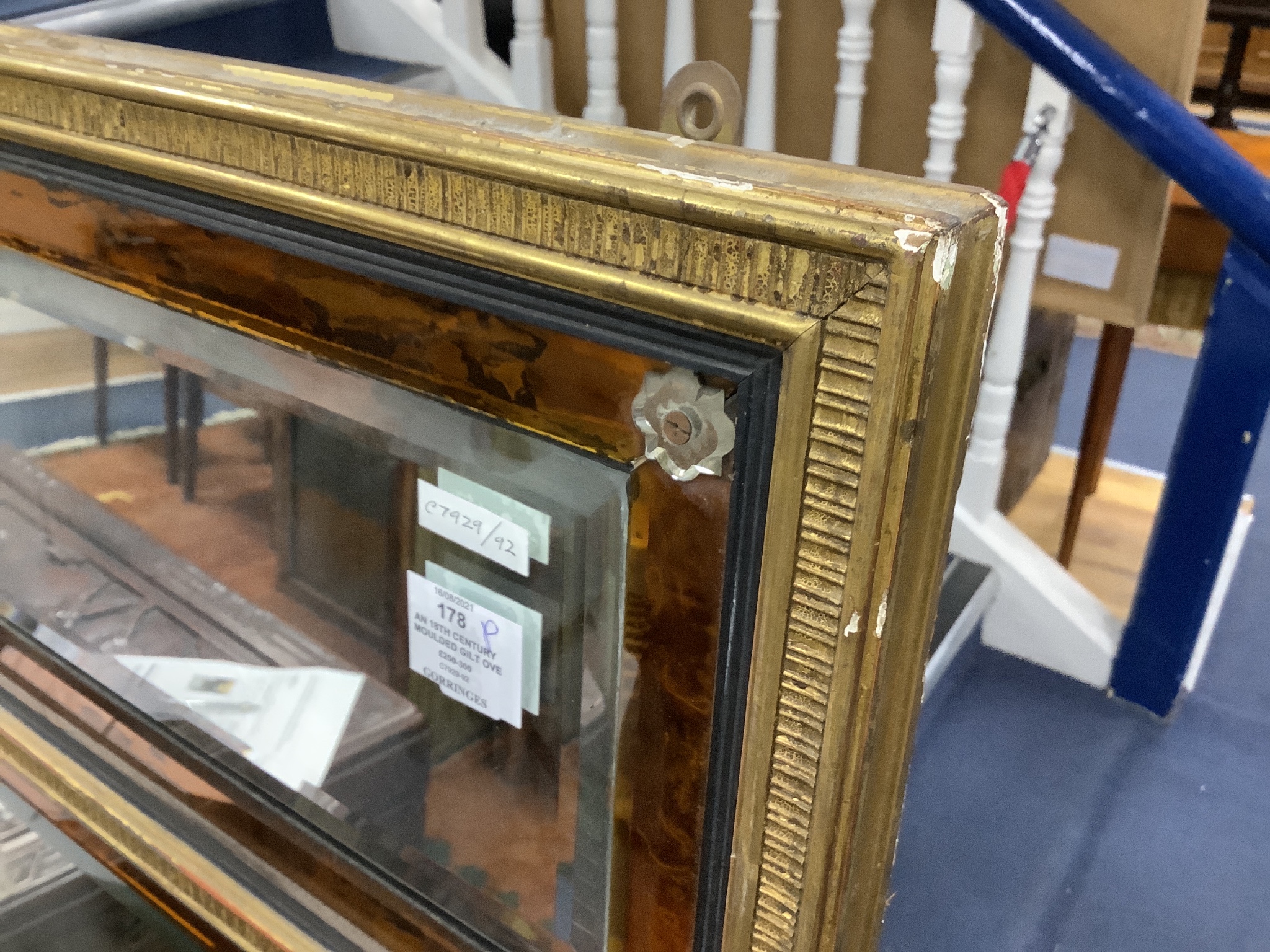 An 18th century moulded gilt overmantel, three mirror plates and amber glass borders and clear glass rosettes